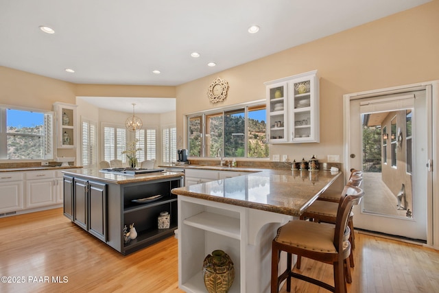 1671 W Catim Way, Prescott, AZ 86305 - kitchen with open shelves, plenty of natural light, white cabinetry, a breakfast bar, and recessed lighting