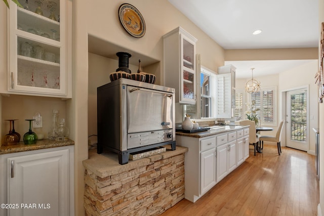 1671 W Catim Way, Prescott, AZ 86305 - kitchen with white cabinets, glass insert cabinets, a chandelier, light wood-style flooring, and recessed lighting