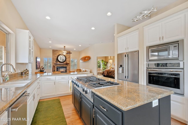1671 W Catim Way, Prescott, AZ 86305 - kitchen featuring stainless steel appliances, white cabinets, gray cabinets, a large fireplace, and light stone countertops