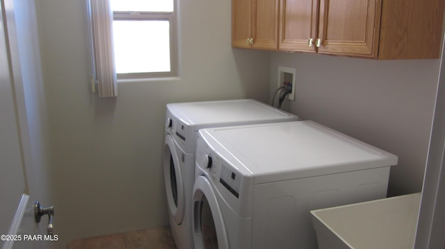 clothes washing area with cabinets, sink, and washing machine and clothes dryer