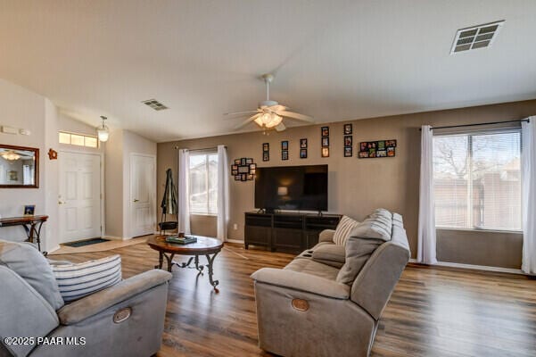 living room with plenty of natural light, vaulted ceiling, visible vents, and a ceiling fan