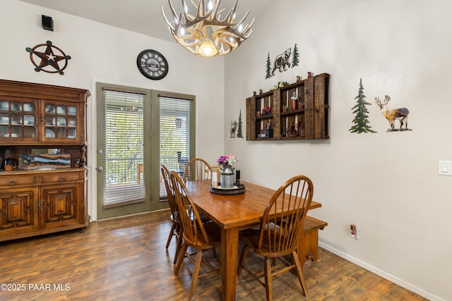 dining space with dark wood finished floors, baseboards, and a chandelier