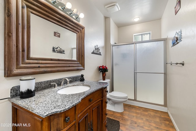 full bath with vanity, wood finished floors, toilet, and a shower stall