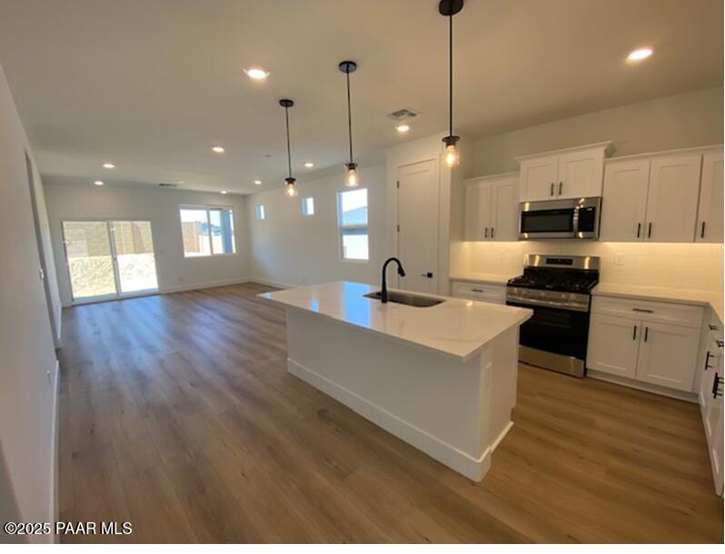 1220 Woodchute Rd Unit 72, Prescott, AZ 86305 - kitchen with stainless steel appliances, a sink, light wood-style floors, white cabinetry, and recessed lighting