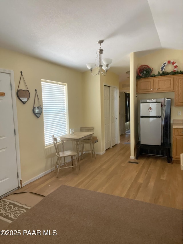 54683 N El Portal Ln, Seligman, AZ 86337 - kitchen featuring light wood-type flooring, baseboards, a chandelier, and freestanding refrigerator