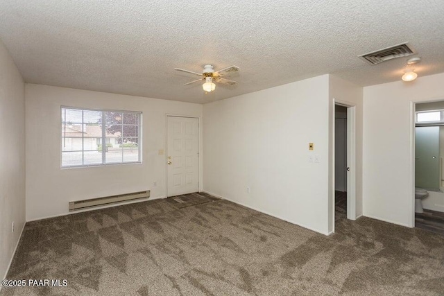 carpeted spare room with a baseboard heating unit, a textured ceiling, visible vents, and ceiling fan