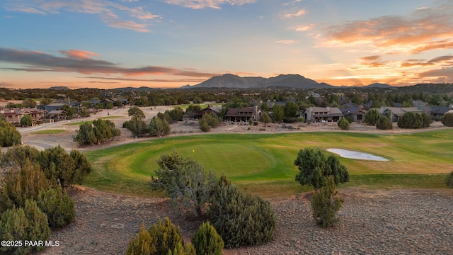 view of home's community with a mountain view, golf course view, and a lawn