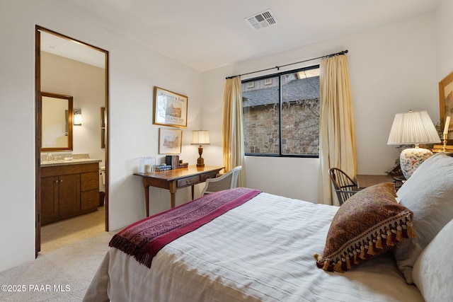 bedroom featuring connected bathroom, visible vents, and light colored carpet