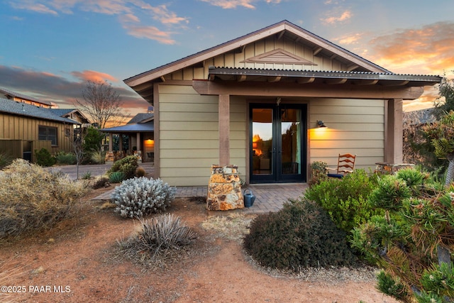 rear view of house with french doors and board and batten siding