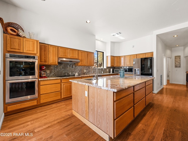 22891 S Lakewood Dr, Yarnell, AZ 85362 - kitchen featuring a kitchen island with sink, stainless steel double oven, decorative backsplash, and a sink