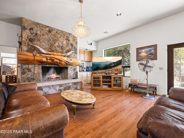 22891 S Lakewood Dr, Yarnell, AZ 85362 - living room featuring light wood-type flooring, a notable chandelier, and a stone fireplace