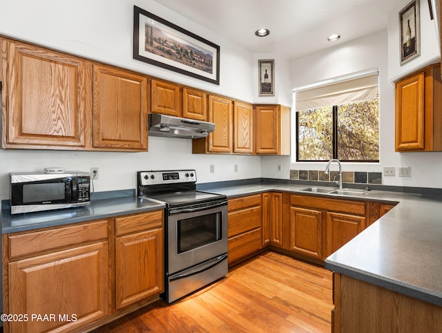 22891 S Lakewood Dr, Yarnell, AZ 85362 - kitchen featuring dark countertops, a sink, brown cabinetry, stainless steel appliances, and under cabinet range hood