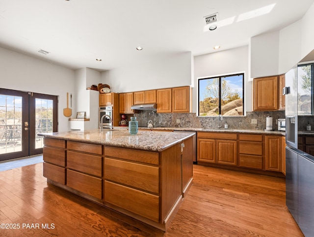 22891 S Lakewood Dr, Yarnell, AZ 85362 - kitchen featuring brown cabinetry, a sink, a wealth of natural light, and stainless steel appliances