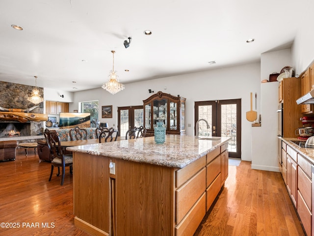 22891 S Lakewood Dr, Yarnell, AZ 85362 - kitchen with french doors, pendant lighting, light wood-type flooring, a sink, and an island with sink