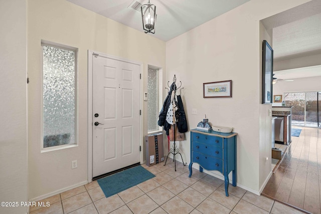 entryway featuring baseboards, tile patterned flooring, and ceiling fan