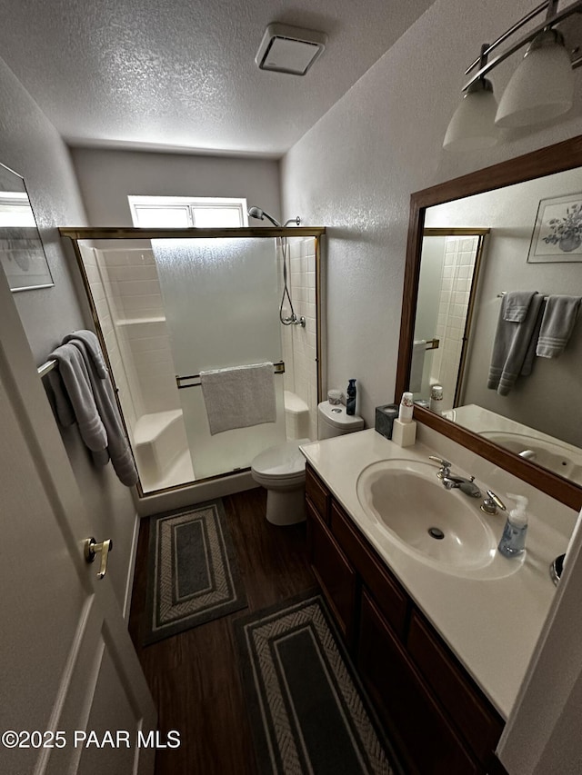 4433 N La Jolla Cir, Prescott Valley, AZ 86314 - bathroom with wood finished floors, a shower stall, a textured wall, a textured ceiling, and vanity