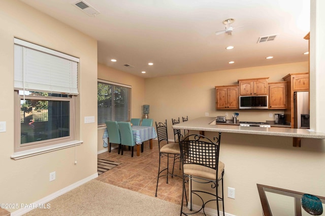 12933 Ponce St, Dewey-Humboldt, AZ 86327 - kitchen featuring stainless steel appliances, a breakfast bar, recessed lighting, light countertops, and light colored carpet