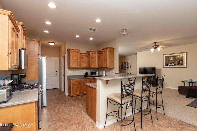 12933 Ponce St, Dewey-Humboldt, AZ 86327 - kitchen featuring a kitchen bar, appliances with stainless steel finishes, ceiling fan, recessed lighting, and a peninsula