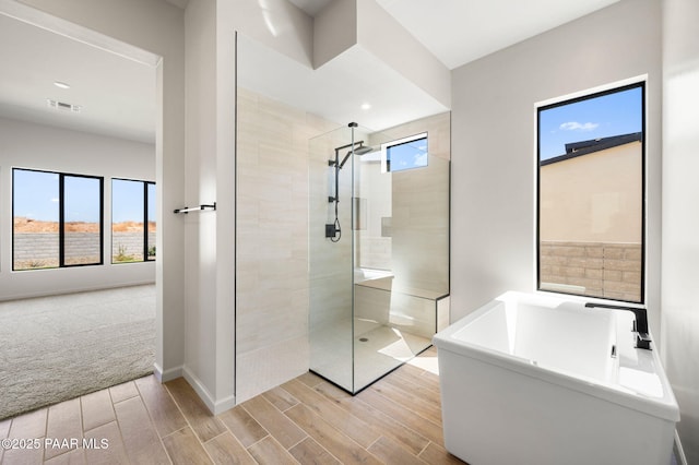 5734 E Hahn St, Prescott Valley, AZ 86314 - bathroom featuring a walk in shower, visible vents, baseboards, a freestanding tub, and wood finish floors