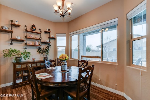 dining room with an inviting chandelier, baseboards, and dark wood finished floors