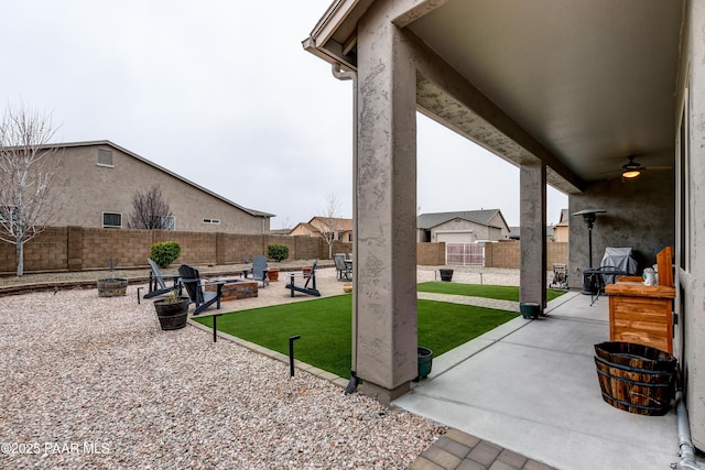 view of patio / terrace featuring a ceiling fan, a fenced backyard, and a fire pit