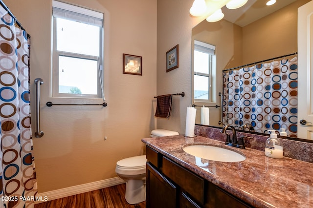 bathroom featuring vanity, plenty of natural light, wood finished floors, and toilet