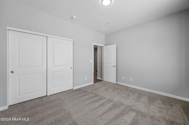 unfurnished bedroom with a closet, carpet flooring, and baseboards
