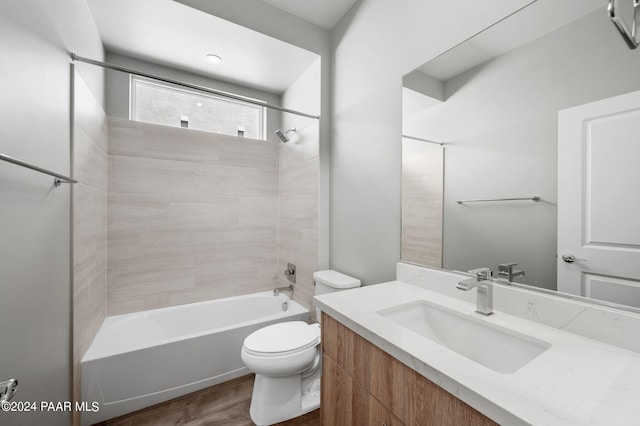 bathroom featuring toilet, wood finished floors, vanity, and shower / washtub combination