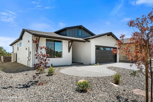 view of front of house with a garage, driveway, and stucco siding