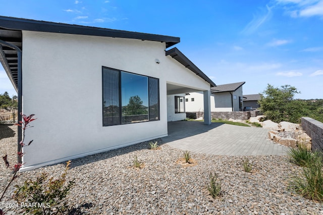 back of property featuring a patio and stucco siding