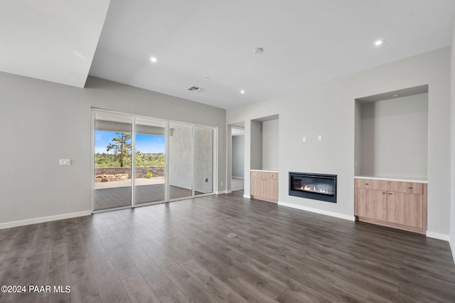 unfurnished living room featuring dark wood finished floors, a glass covered fireplace, visible vents, recessed lighting, and baseboards