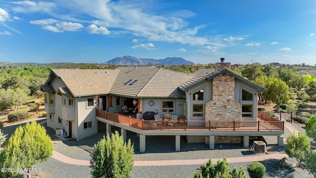 back of house featuring cooling unit and a deck with mountain view