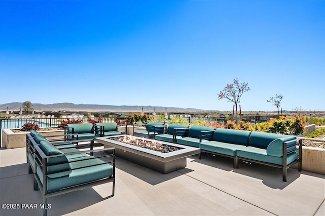 view of patio / terrace featuring an outdoor living space with a fire pit and a mountain view