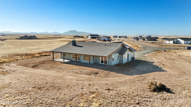 exterior space with a mountain view, a patio area, and central air condition unit