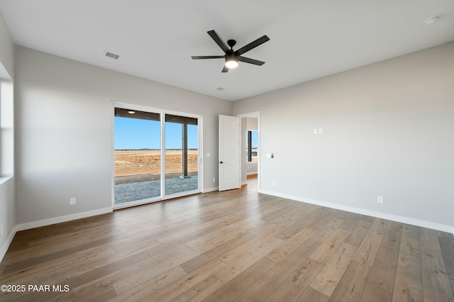 spare room with ceiling fan and light wood-type flooring