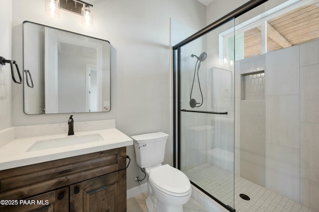 bathroom with vanity, a shower with door, and toilet