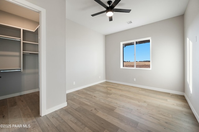 unfurnished bedroom featuring ceiling fan, light wood-type flooring, and a closet