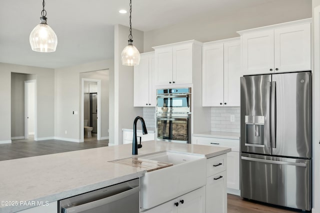 kitchen with white cabinetry, decorative light fixtures, and stainless steel appliances