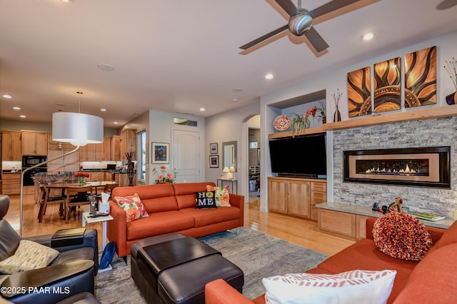 1690 Stable Rock Rd, Prescott, AZ 86303 - living room with light wood finished floors, recessed lighting, a fireplace, ceiling fan, and arched walkways