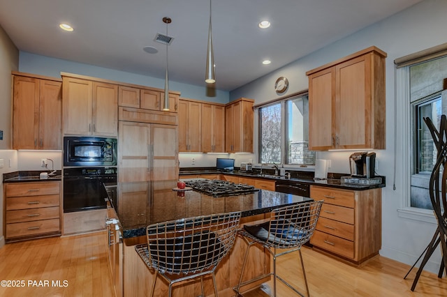 1690 Stable Rock Rd, Prescott, AZ 86303 - kitchen featuring a center island, black appliances, light wood finished floors, and dark stone countertops