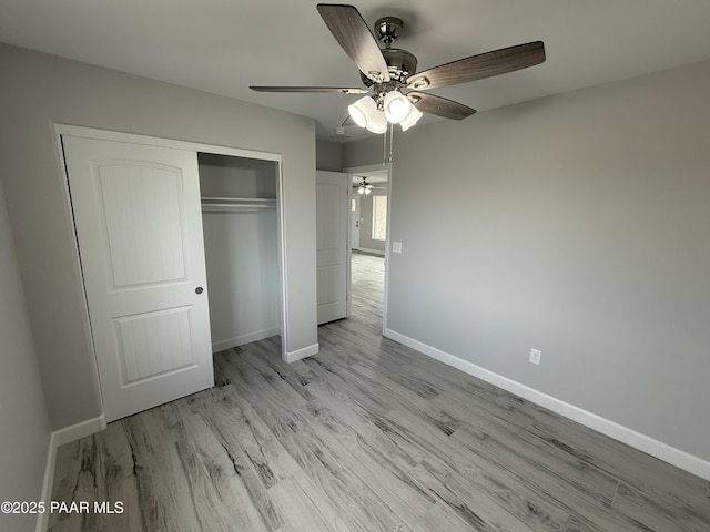 unfurnished bedroom featuring ceiling fan, light hardwood / wood-style flooring, and a closet