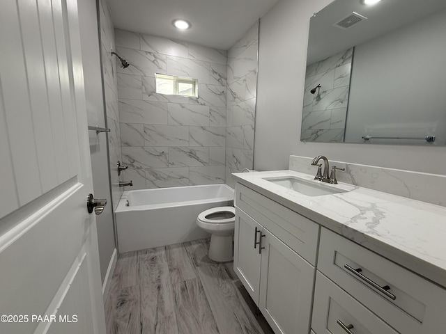 full bathroom with toilet, vanity, wood-type flooring, and tiled shower / bath