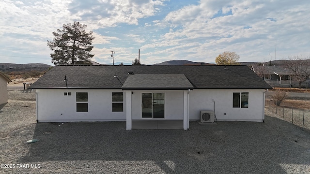 rear view of house with ac unit and a patio