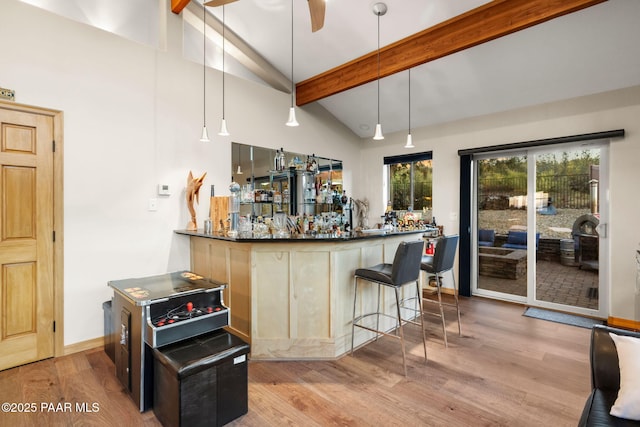 bar featuring ceiling fan, beam ceiling, hanging light fixtures, and light wood-type flooring