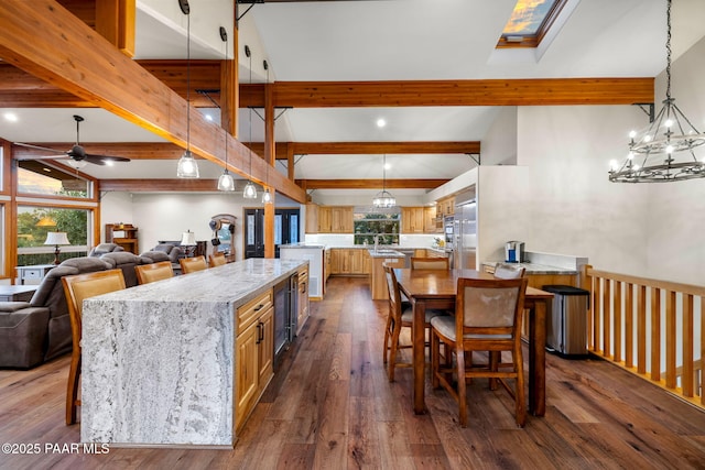 kitchen featuring pendant lighting, dark hardwood / wood-style floors, light stone counters, and a breakfast bar area