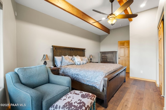 bedroom featuring beamed ceiling, ceiling fan, and wood-type flooring