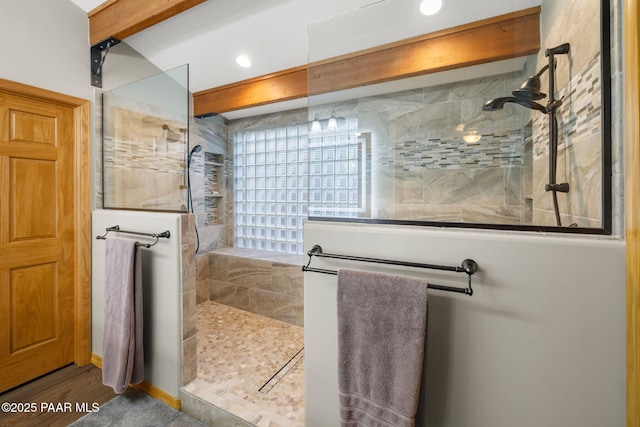 bathroom with hardwood / wood-style floors and a tile shower