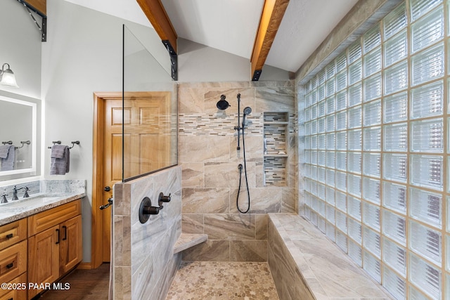 bathroom featuring vanity, a tile shower, and lofted ceiling with beams