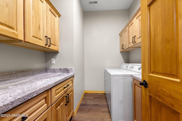 laundry room with separate washer and dryer, dark hardwood / wood-style flooring, and cabinets