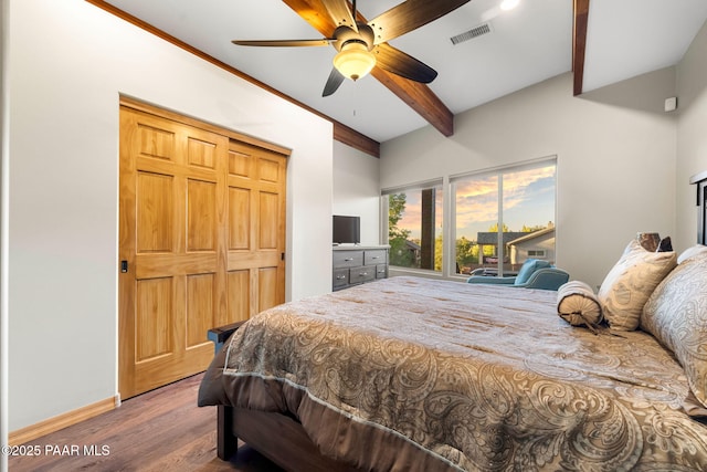 bedroom featuring wood-type flooring, ceiling fan, beam ceiling, and a closet